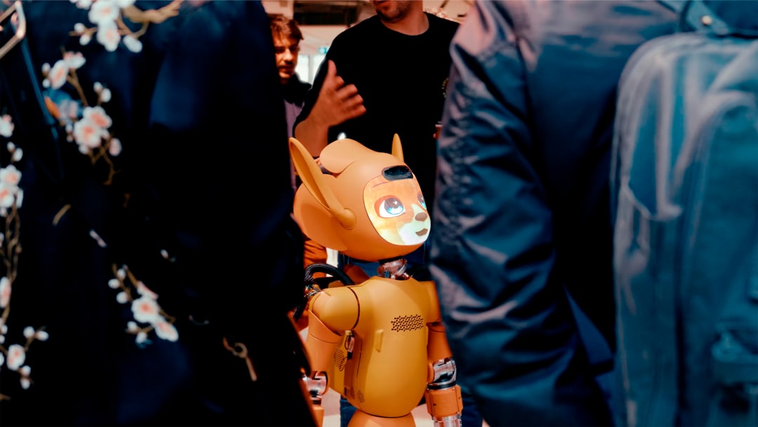 A small orange robot stands among people.