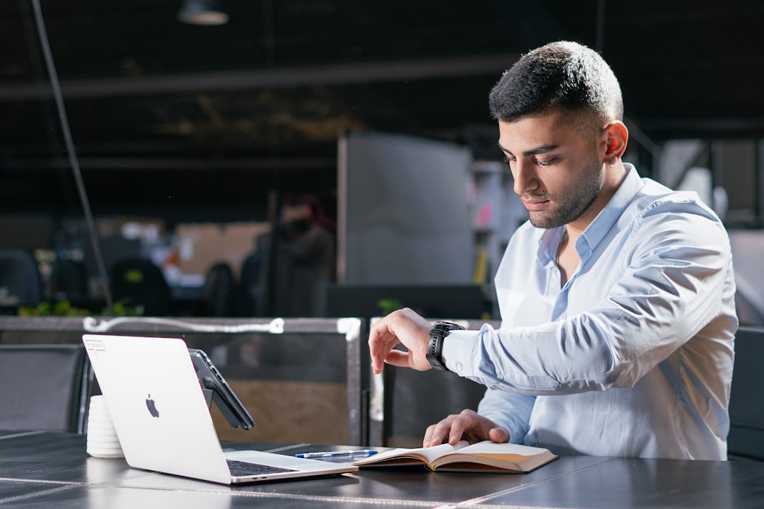 A man sitting at a table working on a laptop